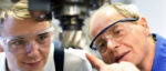 Älterer Mann und Schüler vor einer CNC-Maschine